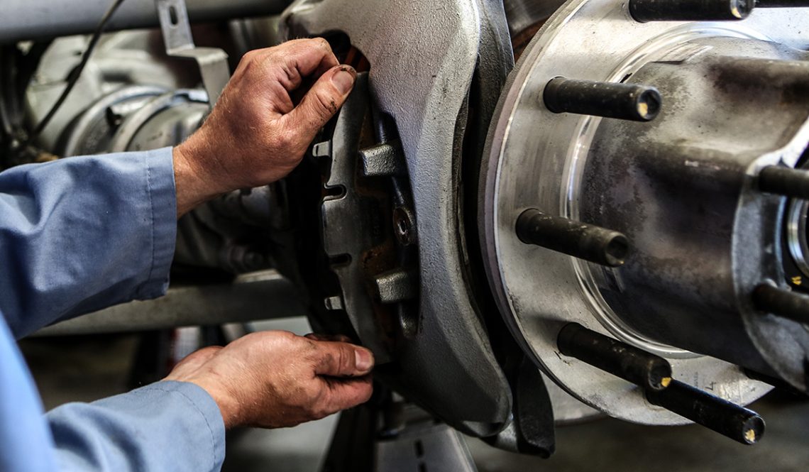 Photo of hands working on brake shoe of heavy duty truck